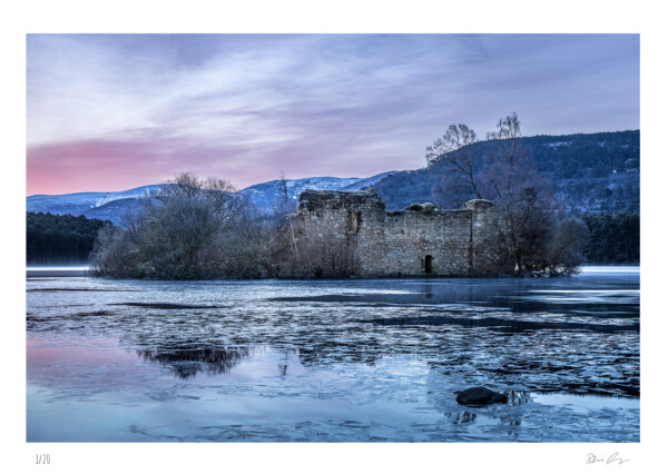 A castle in a frozen Loch at sunrise